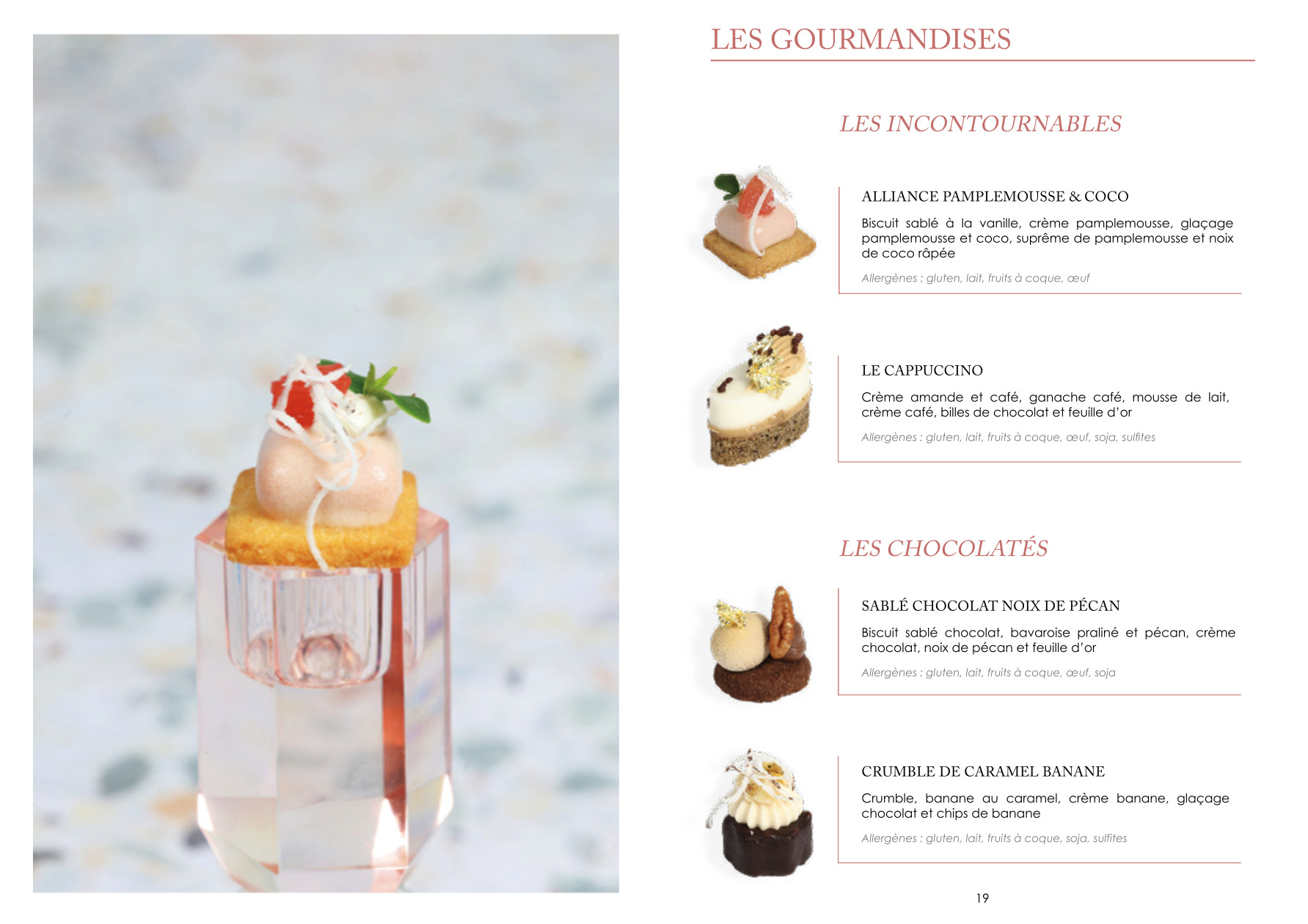 Un dessert délicat avec une crème rose, une tranche de pamplemousse et une garniture de chocolat blanc repose sur un petit biscuit carré au sommet d'un piédestal clair et facetté sur un fond clair et moucheté. La carte des desserts français est présentée à droite.