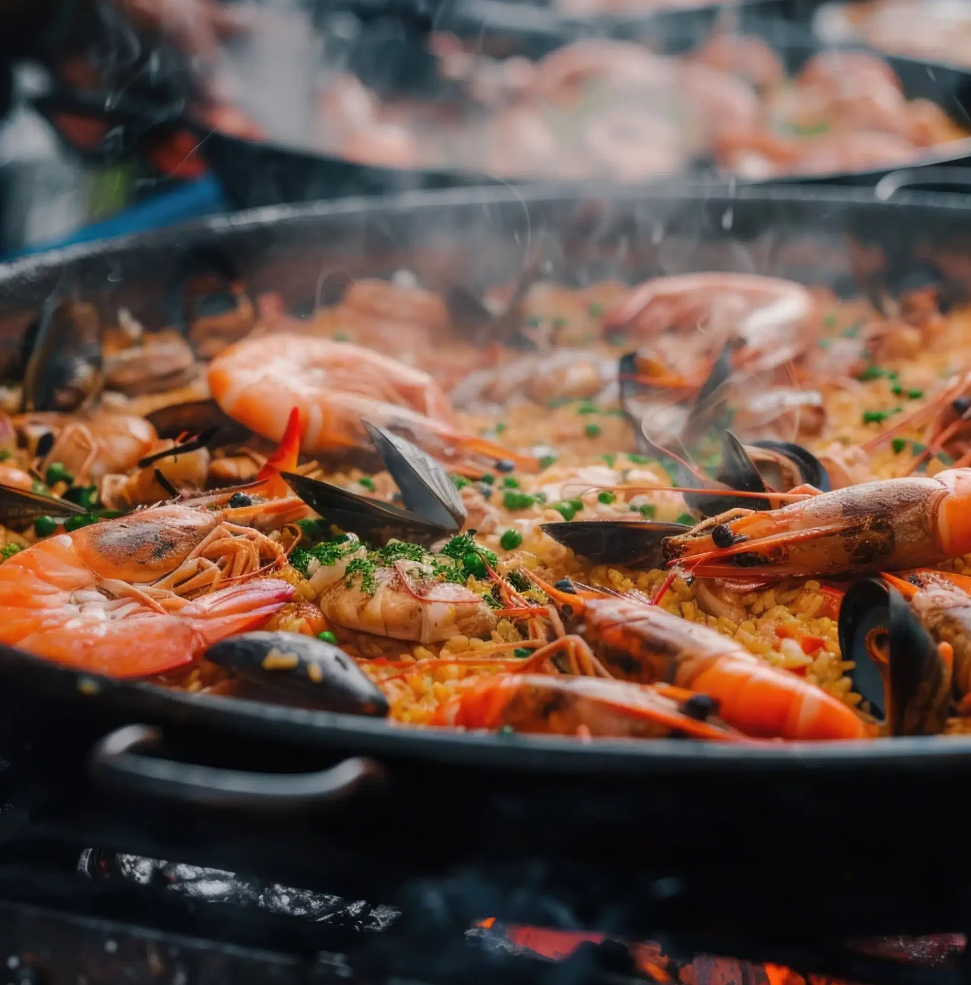 Gros plan sur la PAËLLA PARTY (400g/pers & Matériel fourni), remplie de crevettes, de moules, de riz et d'herbes fumantes, en train de cuire sur une flamme nue.