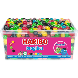 Une barquette en plastique transparent contenant des bonbons HARIBO WORLD MIX (1Kg) avec une étiquette montrant le logo Haribo, des personnages de dessins animés et des bonbons colorés à côté du mot "Original".