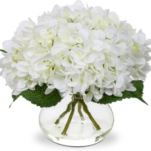 Le CENTRE DE TABLE présente des fleurs d'hortensia blanches et des feuilles vertes dans un vase rond en verre, avec des tiges visibles pour un aspect propre et élégant.