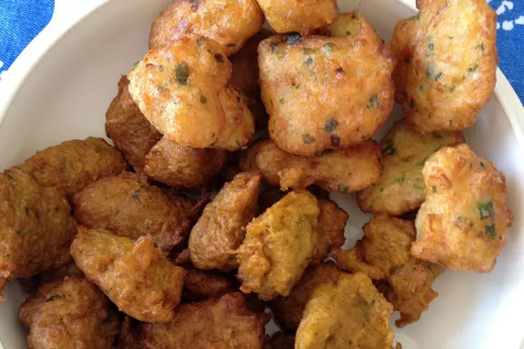 Une barquette de 20 BOUDIN AU CRABE (40g chacun), des beignets de forme irrégulière, dorés, avec des herbes apparentes et des mouchetures vertes.