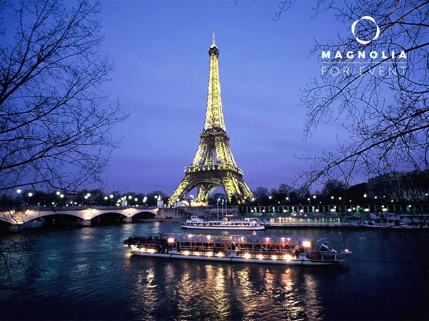 La Tour Eiffel s'illumine au crépuscule, avec des bateaux illuminés sur la Seine et des branches d'arbres dénudées qui encadrent la vue. Le logo de LA PÉNICHE LOCET (75013) apparaît dans le coin supérieur droit.