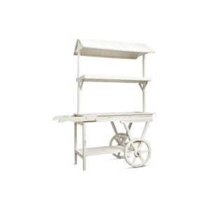 Le CHARIOT AVEC 10 BONBONNIERES 13Kg (Bonbons non fournis) est un chariot de marché en bois blanc avec un auvent, une étagère latérale, deux grandes roues à rayons et une surface d'exposition plane, sur fond blanc.