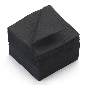 Une pile de SERVIETTES NOIRES TRAITEUR COCKTAIL (20 x 20 cm, lot de 50) est soigneusement pliée, la serviette supérieure étant légèrement soulevée au coin pour montrer sa texture et son épaisseur.