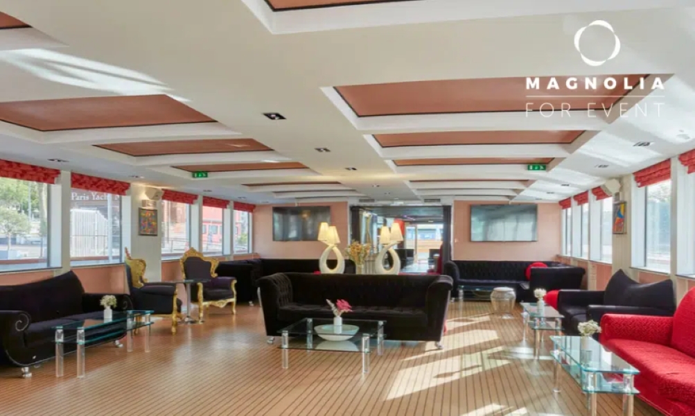 Salle d'événements élégante "LE YACHT CLIPPER (75015)" avec des canapés et des fauteuils noirs et dorés, de grandes fenêtres, des planchers en bois et des lampes décoratives. Le logo apparaît dans le coin supérieur droit.