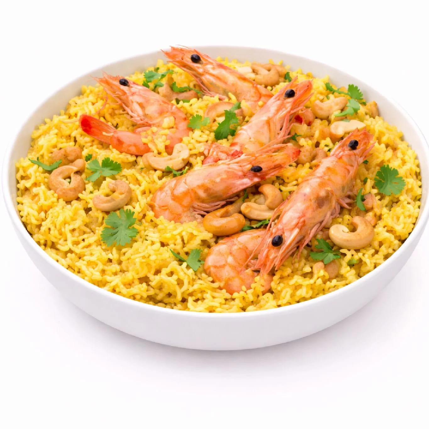 Une portion de CREVETTES BIRIYANI (300g) comprenant du riz jaune, des crevettes entières, des noix de cajou et de la coriandre fraîche dans un bol blanc sur fond blanc.