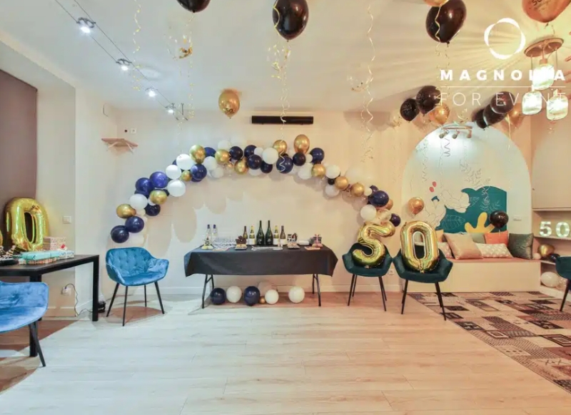 L'ESPACE DES AMIS DU 15ème (75015) organise un 50ème anniversaire avec des ballons dorés, noirs et blancs, de gros ballons dorés " 50 ", une table de boissons, des chaises bleues et un éclairage festif.