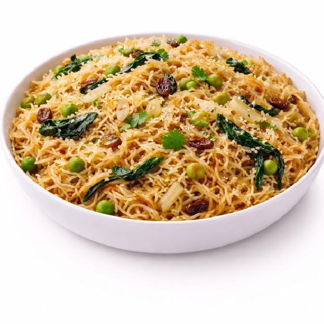 Un bol blanc de RIZ À L'ORIENTAL AUX VERMICELLES ET AUX PINS (min. 5 portions de 250 g) comprenant des vermicelles cuits, des pois verts, des feuilles de curry, des raisins secs, des herbes et des graines de sésame est présenté sur un fond blanc.