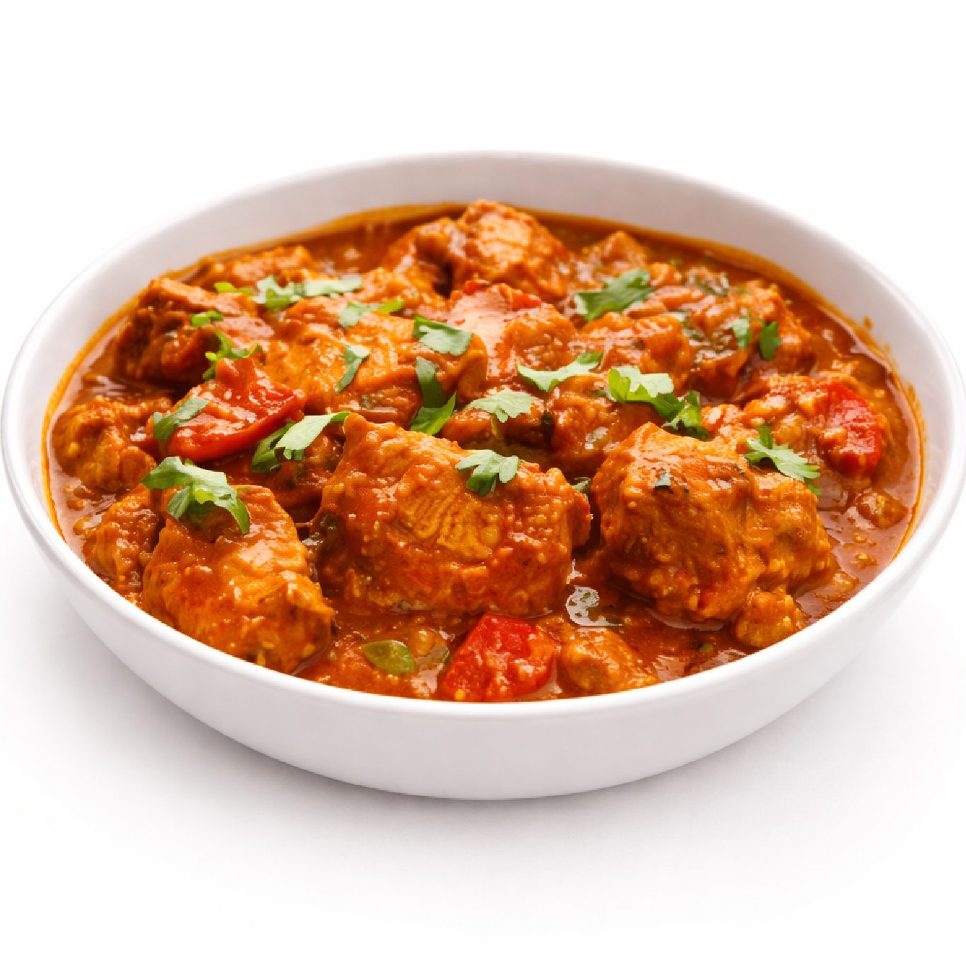 Un bol blanc d'AGNEAU TIKKA (300 g) présente un riche curry rouge avec de tendres morceaux de viande, des tomates et une garniture de coriandre fraîche.