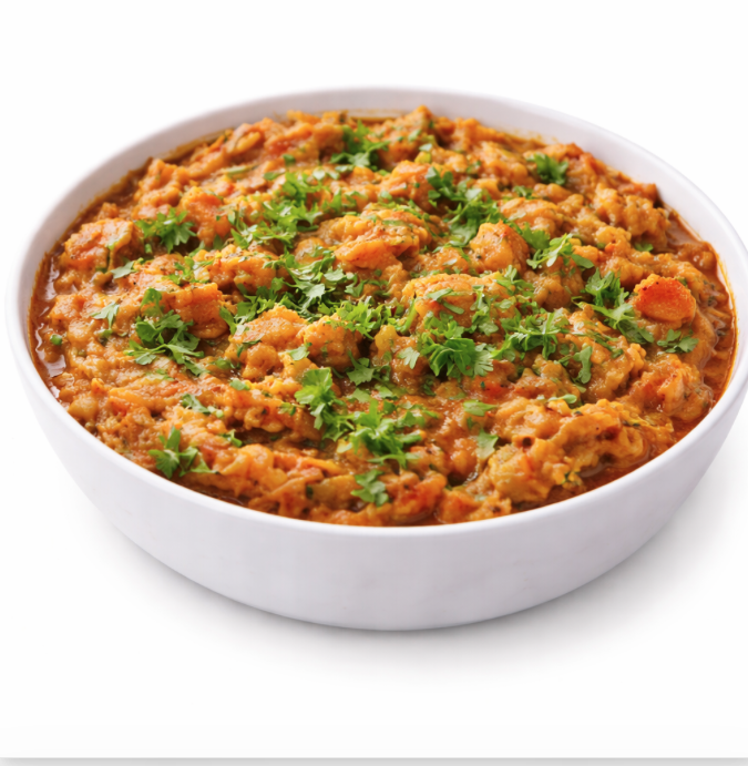 Un bol de BAIGAN BHARTHA (250 g) présente des légumes mélangés dans un curry épais et épicé, garni de coriandre fraîche hachée.
