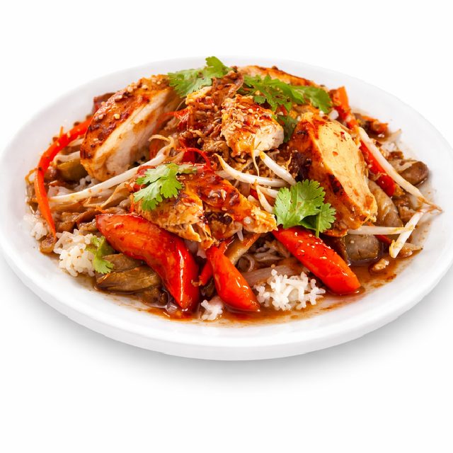 POULET À LA CITRONNELLE (250g/pers) : Tranches de poulet grillé avec riz sauté, poivrons rouges, germes de soja, coriandre et sauce brune savoureuse servis dans un plat blanc.