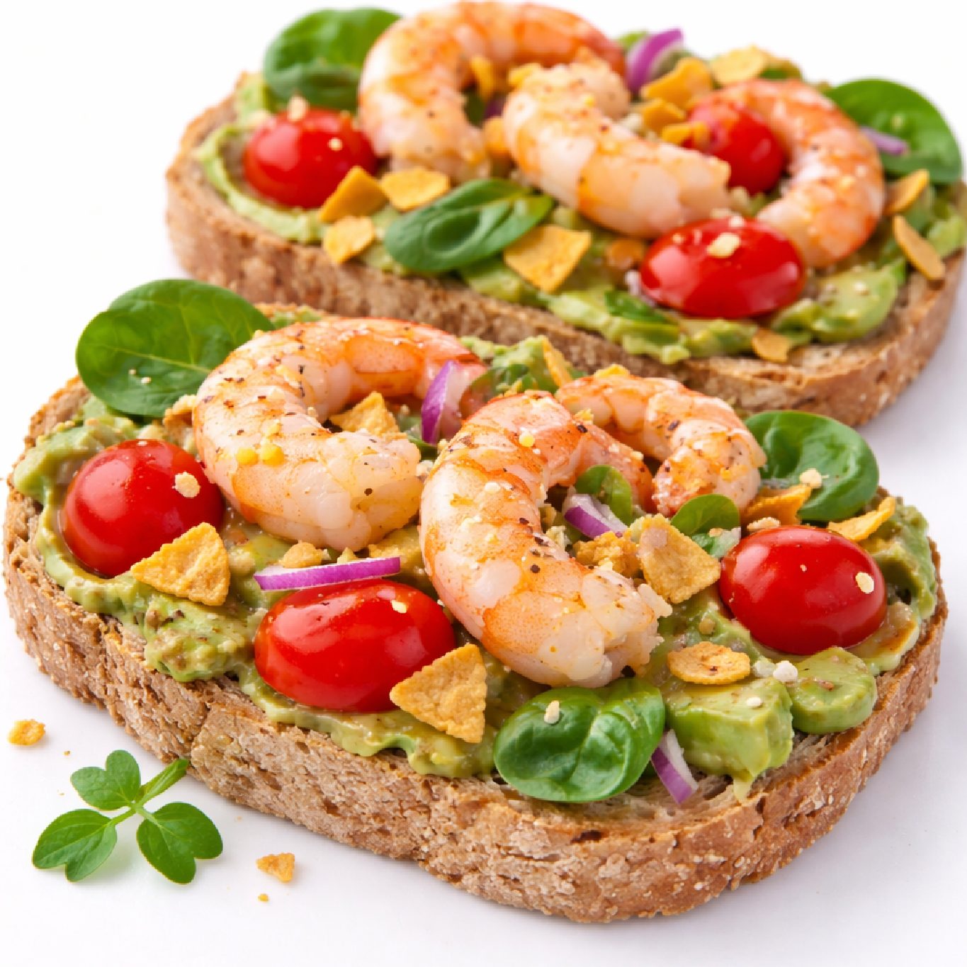 TOAST DE PLANTAIN À L'AVOCAT ET AUX CREVETTES (Plateau de 10 pièces) : des toasts de plantain garnis d'avocat, crevettes, tomates cerises, épinards, oignon rouge et herbes fraîches pour un apéritif savoureux.